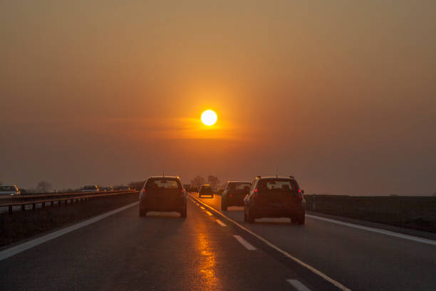 tráfico en carretera europeo con los coches y romántica puesta de sol en frente - rebasar fotografías e imágenes de stock