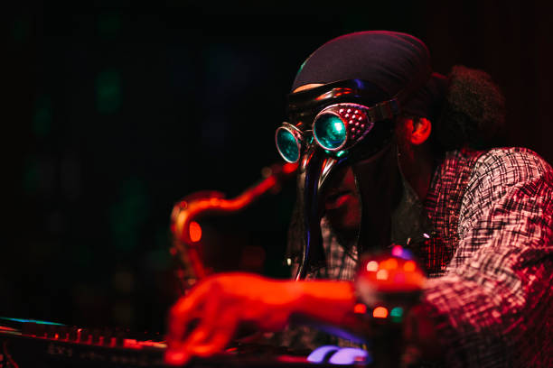 istock Man with mask playing music on stage 996898998