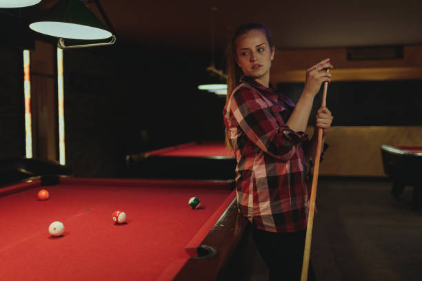 istock Young woman playing pool indoors 996899406