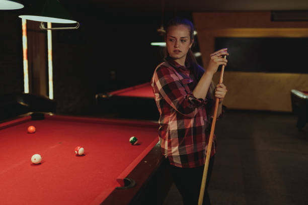 istock Young woman playing pool indoors 996899460