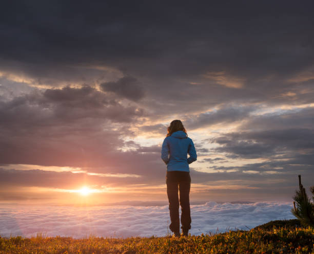 istock Young woman looking at the spectacular sunrise 996902252