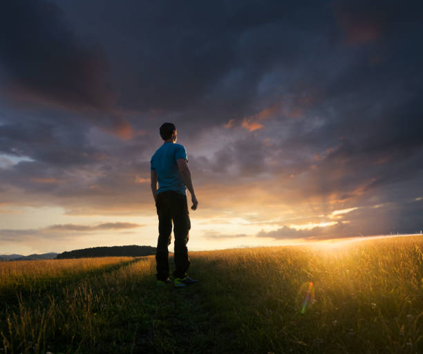 istock Man admiring the beautiful sunset after a heavy rain 996903256