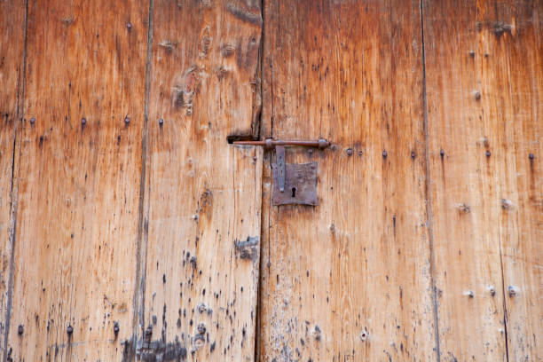 istock Old wood door with rusty metallic lock 996904538