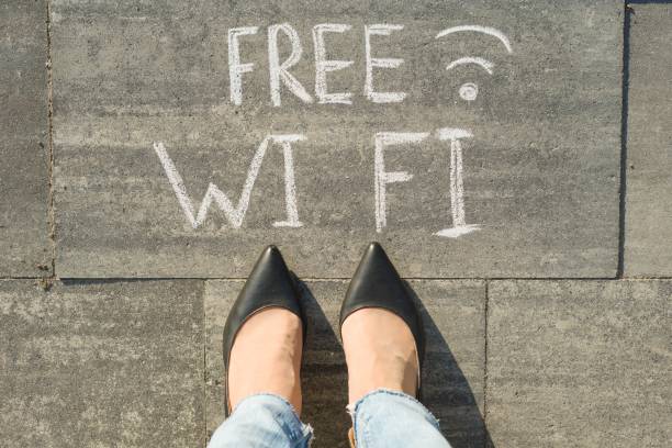 istock Female feet with text free wi fi written on grey sidewalk. 996906800