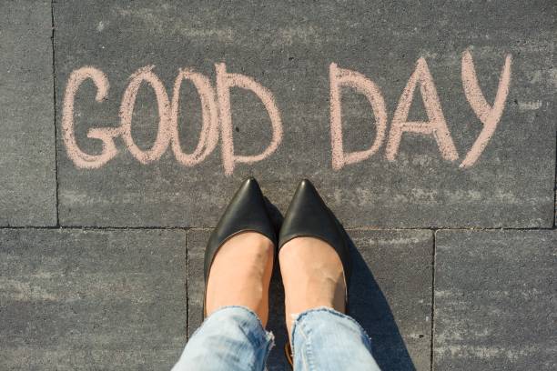istock Female feet with text good day written on grey sidewalk. 996913392
