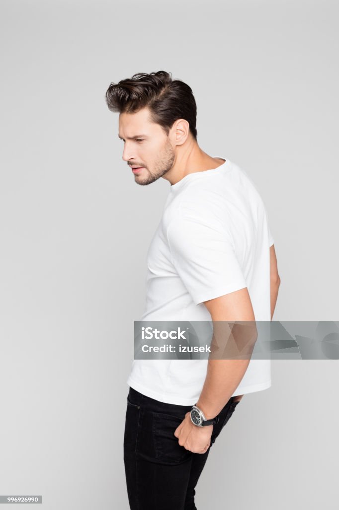 Smart young guy posing on grey background Portrait of smart young guy posing on grey background 25-29 Years Stock Photo