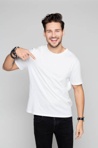 souriant jeune homme vers le bas - plain shirt photos et images de collection