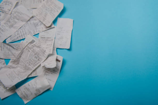 Pile of shopping receipts on blue background stock photo