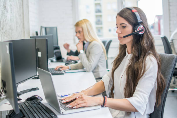 istock Female customer support phone operator working on laptop at workplace. 996934582