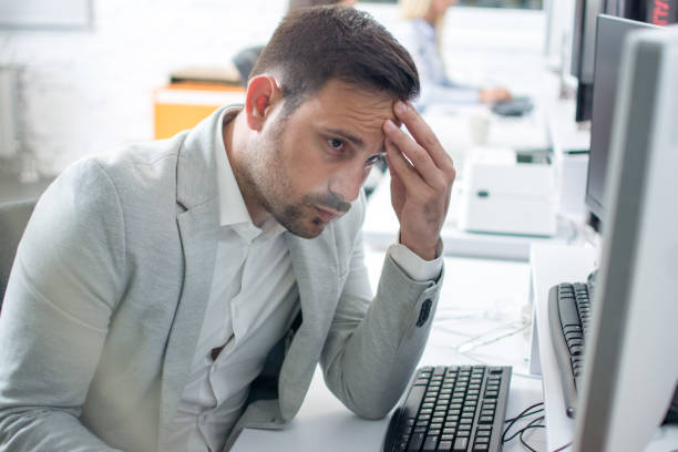 istock Businessman having head pain while working on computer in office 996935758