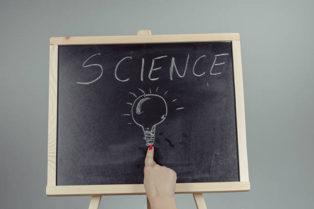 istock A teacher writing science, drawing chemistry elements on dark chalkboard by hand 996939482