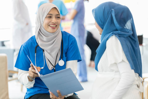 istock Confident Malaysian ob/gyn talks with pregnant patient 996939690