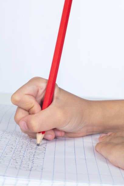 istock Children's hands holding pencil and doing homework 996953000