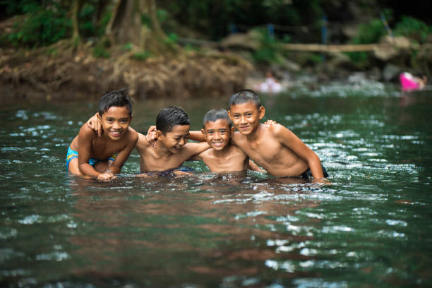 istock Little Indonesian boys playing in a river 996957060