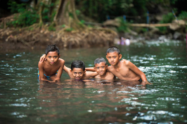 istock Little Indonesian boys playing in a river 996957062