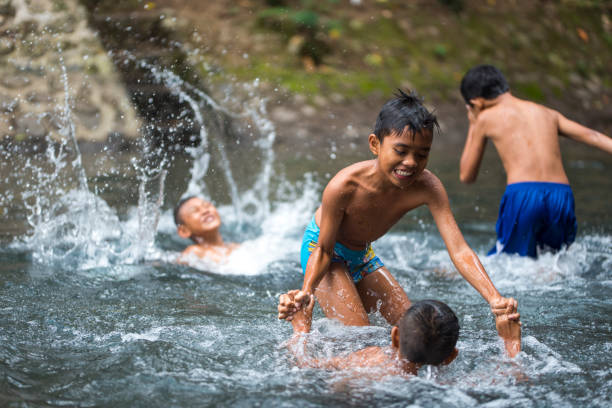 istock Little Indonesian boys playing in a river 996957176