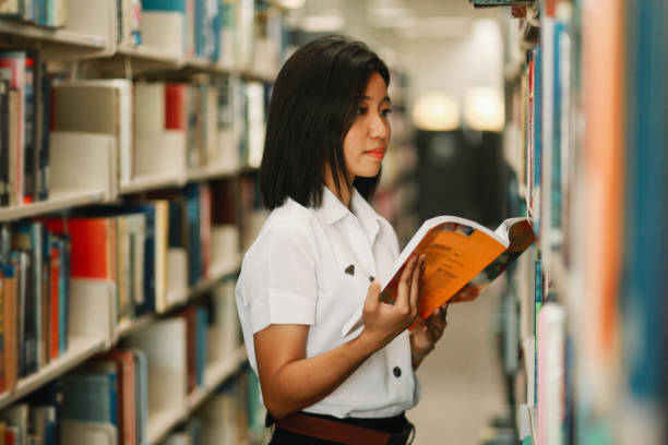 istock Young Asian student is searching for books in the library 996959072