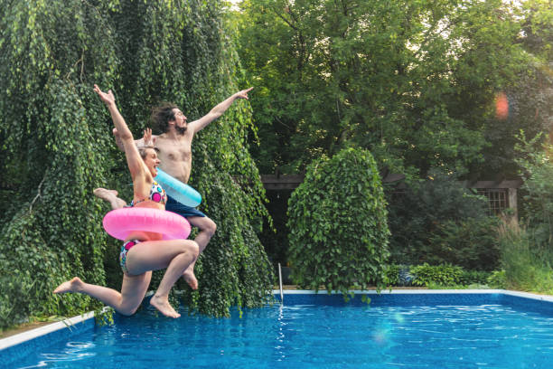 istock Couple having fun in a swimming pool during summer day 996964462