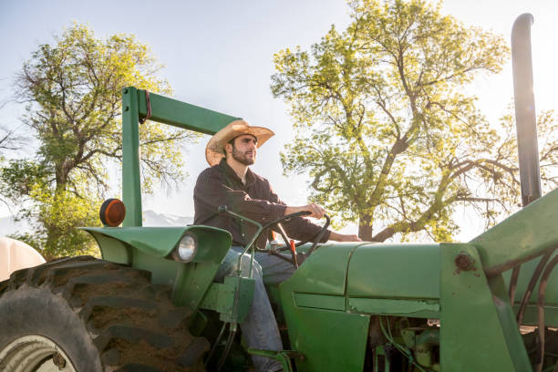 istock Farm worker riding tractor, Utah, USA 996965046