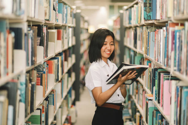 istock Young Asian student is searching for books in the library 996970342