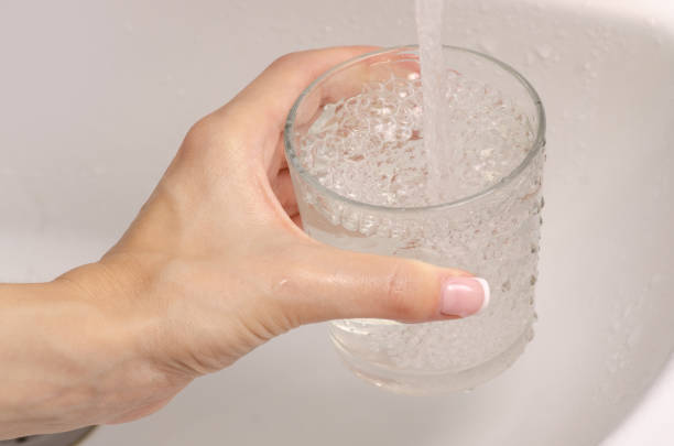 istock Female hand water in a glass washbasin 996970558