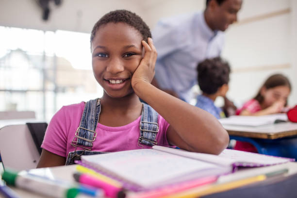 istock Confident girl sitting at desk in classroom 996975526