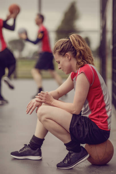 istock Female trainer coaching a basketball team during a street ball training session 996975712