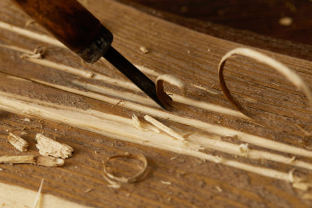 istock partial view of chisel sticking in wooden plank with scobs 996975740