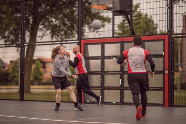 istock Female trainer coaching a basketball team during a street ball training session 996976196