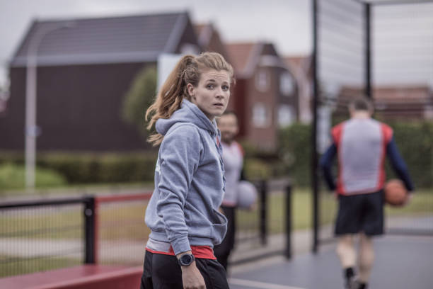 Female trainer coaching a basketball team during a street ball training session