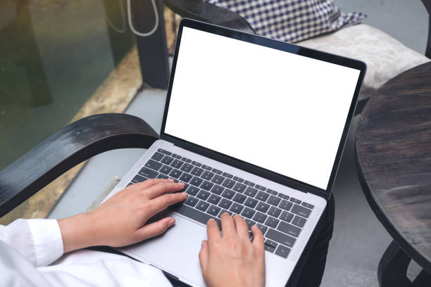 istock Top view mockup image of a woman using and typing on laptop with blank white desktop screen while sitting on a chair 996979768