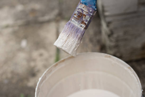istock Paintbrush and open bucket with white colour 996984034