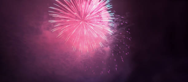 istock horizontal banner with pink fireworks and smoke in night skiy 996985804