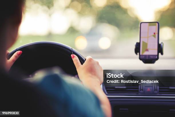 A Woman Drives A Car At Sunset Stock Photo - Download Image Now - Driving, Car, Global Positioning System