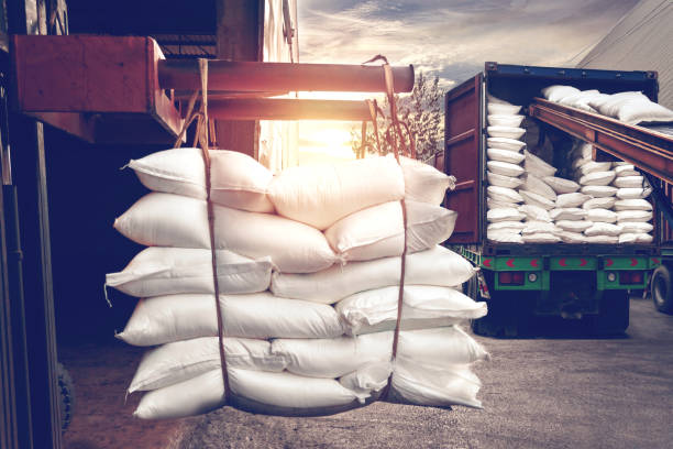 Forklift handling white sugar bags stuffing into a container truck Forklift handling white sugar bags from warehouse for stuffing into container truck for export, vintage tone. bulk carrier stock pictures, royalty-free photos & images