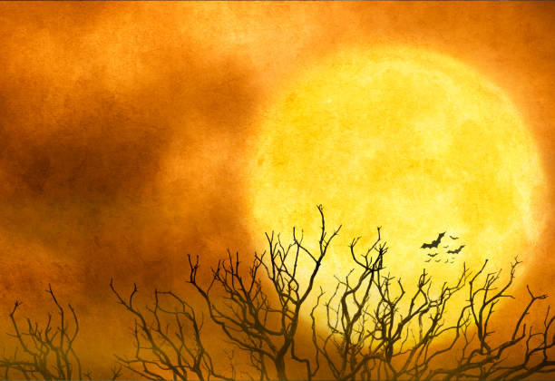 Flying bats and a barren tree are silhouetted against a full moon on Halloween night. The night sky provides ample room for copy and text.