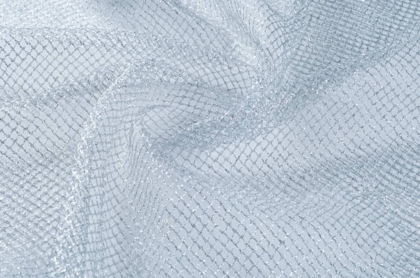 istock fabric, background texture. White silver mesh fabric, with a woven metallic thread. Silver fashion mesh! Flickering beads add texture and shine to the piece. 997007784