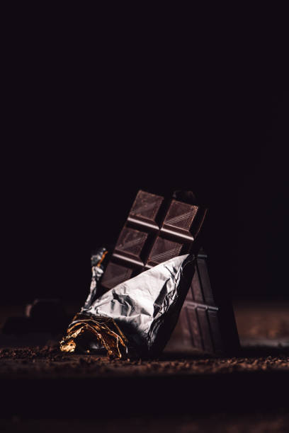 istock close up view of two arranged chocolate bars on wooden table on black background 997008094