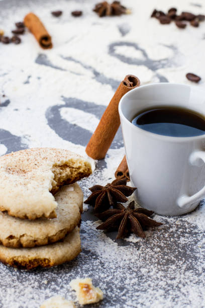 istock Table decorated with biscuit and coffee ingredients, fresh coffee and cinnamon sticks with coffee writing made from wheat flour 997043128