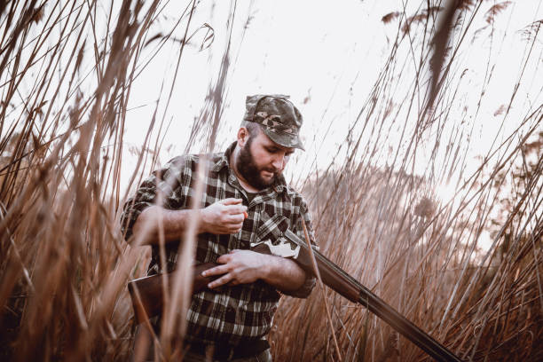 istock Mature Male Hunter Loading Rifle And Preparing For Hunting 997055170