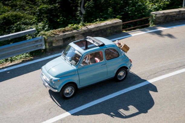 Fiat 500 classic compact Italian family car parked next to the road in Cortina D'Ampezzo in the Italians Dolomites during a springtime day in the Alps.