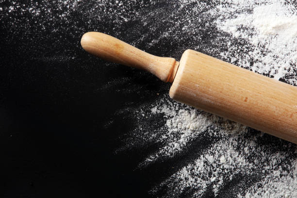 istock Baking background with the rolling pin with flour. On the dark table. Free space for text 997071708