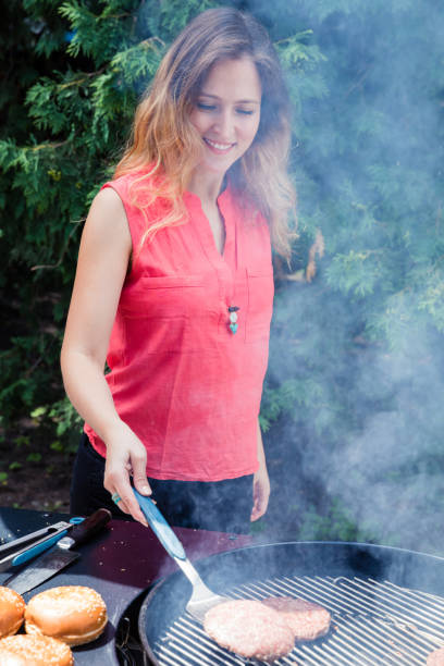 istock Happy woman making barbecue in the backyard. 997075176