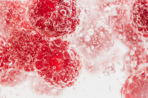 istock Fresh raspberries in water wiht air bubbles. 997110166