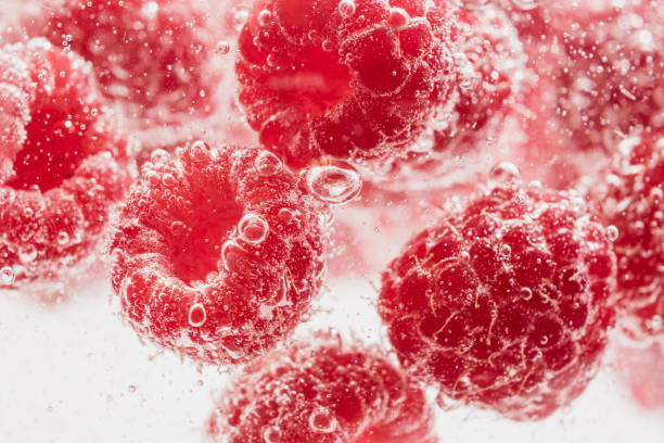 istock Fresh raspberries in water wiht air bubbles. 997110200