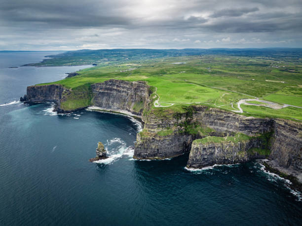 Beautiful Cliffs of Moher Ireland Wild Atlantic Way Areal view towards the beautiful and famous Cliffs of Moher under a rainy and dramatic skyscape in summer. Burren Region, County Clare, Ireland doolin photos stock pictures, royalty-free photos & images