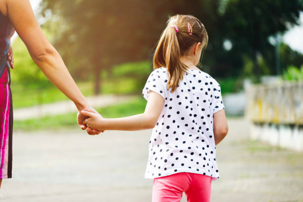 istock Mother and daughter holding hands in nature 997118272