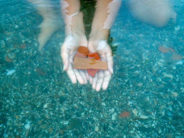istock in the water-stones in the hands 997121512