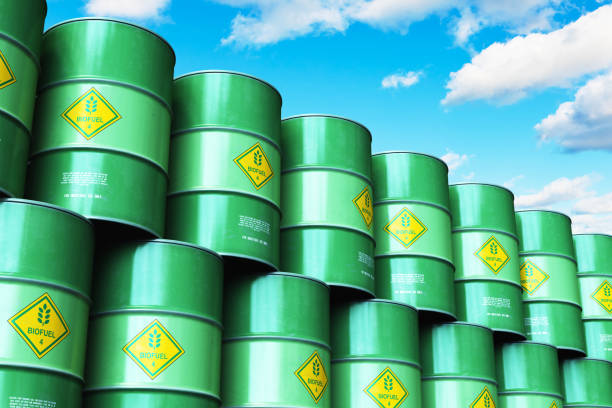 istock Group of green stacked biofuel drums against blue sky with clouds 997122948