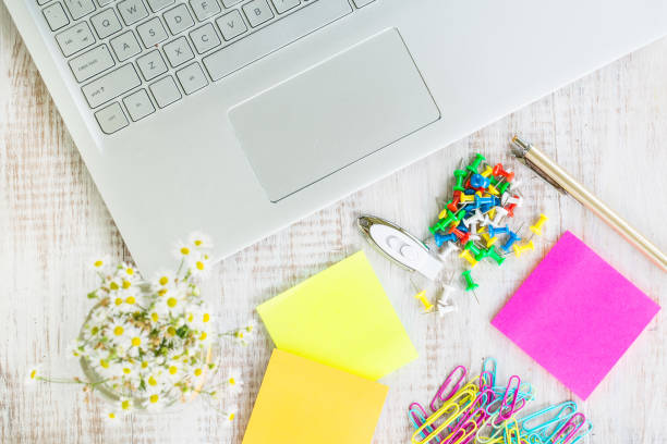 istock Work Desk With Laptop Computer Office Supplies and Flowers 997162864